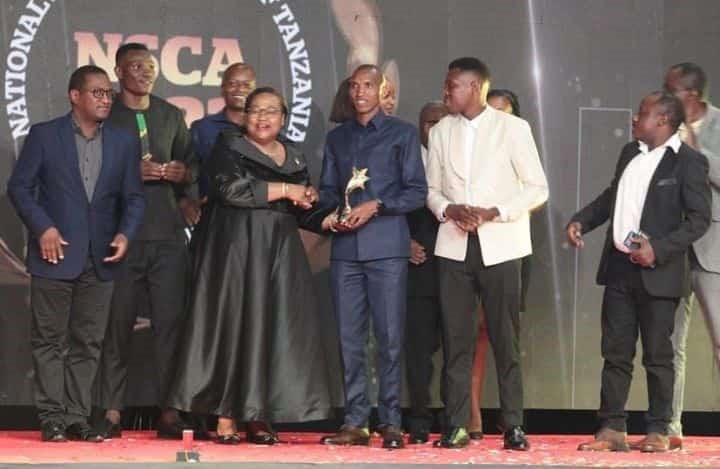 Mh Waziri wa Utamaduni, Sanaa na Michezo Dk Pindi Chana akimkabidhi Mshindi wa Tuzo ya Jumla kwa Wanaume ya mwaka 2022 Sajenti Alphonce Simbu katika